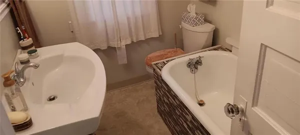 a bathroom with a sink and mirror with bathtub