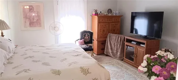a bedroom with a bed and a mirror on dresser