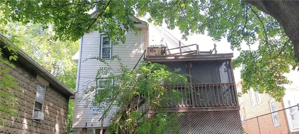 a view of a house with a tree and wooden fence