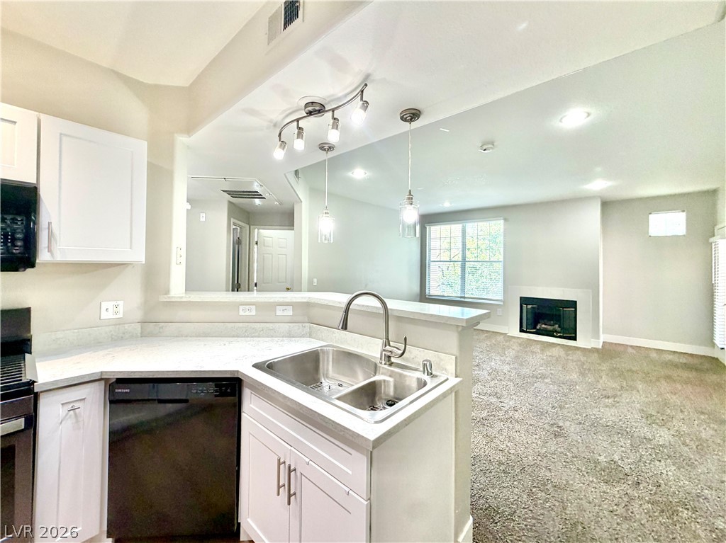 8555 West Russell Road, Unit 2018 Las Vegas, NV 89113 - Photo 12 of 23 A well-appointed kitchen seamlessly flows into a welcoming living area, complete with a fireplace for cozy evenings.