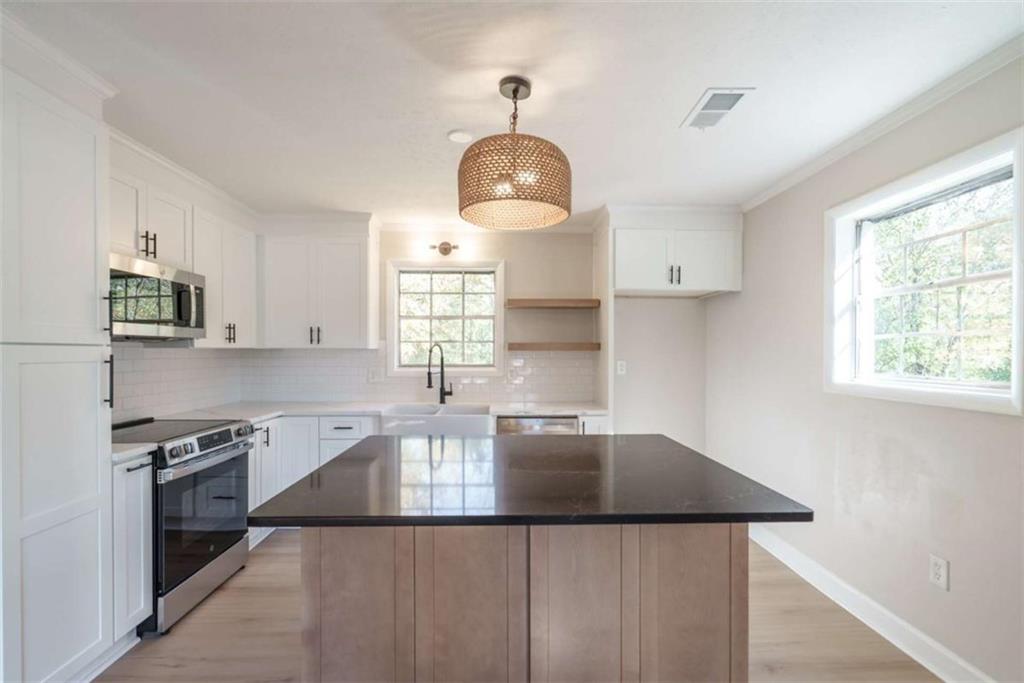 511 Lee Byrd Road Loganville, GA 30052 - Photo 11 of 32 a kitchen with stainless steel appliances granite countertop a sink a stove and a refrigerator