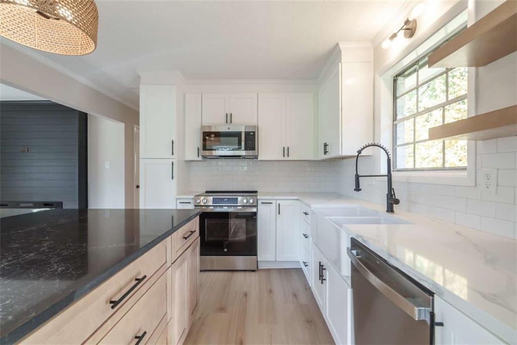 511 Lee Byrd Road Loganville, GA 30052 - Photo 12 of 32 a kitchen with stainless steel appliances granite countertop a sink stove and refrigerator