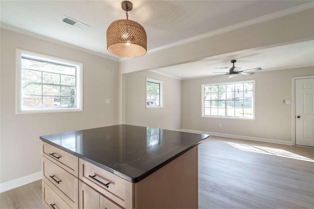 511 Lee Byrd Road Loganville, GA 30052 - Photo 13 of 32 an open kitchen with wooden floor and chandelier