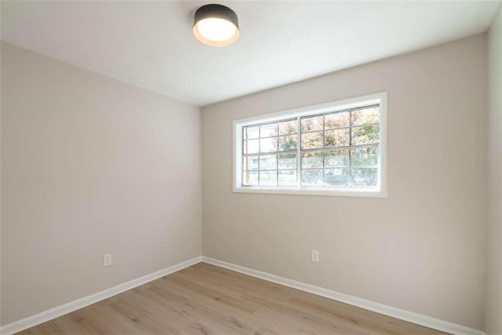 511 Lee Byrd Road Loganville, GA 30052 - Photo 20 of 32 an empty room with wooden floor and windows