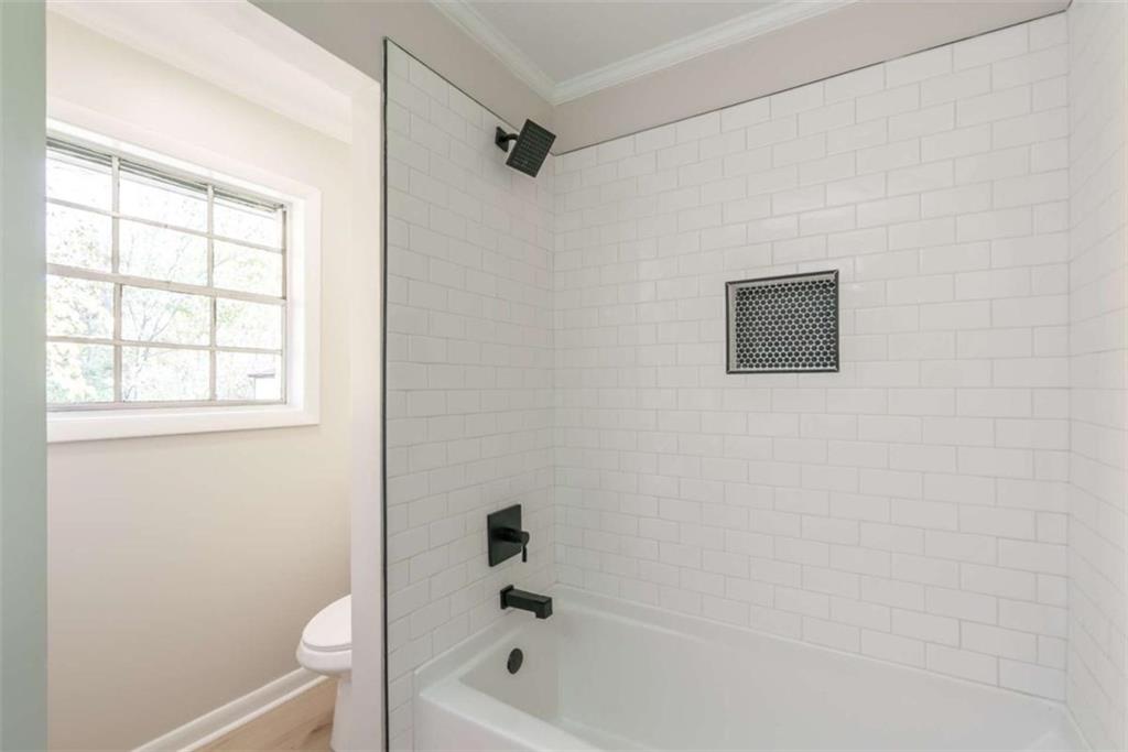 511 Lee Byrd Road Loganville, GA 30052 - Photo 22 of 32 a bathroom with a bathtub a window and a shower