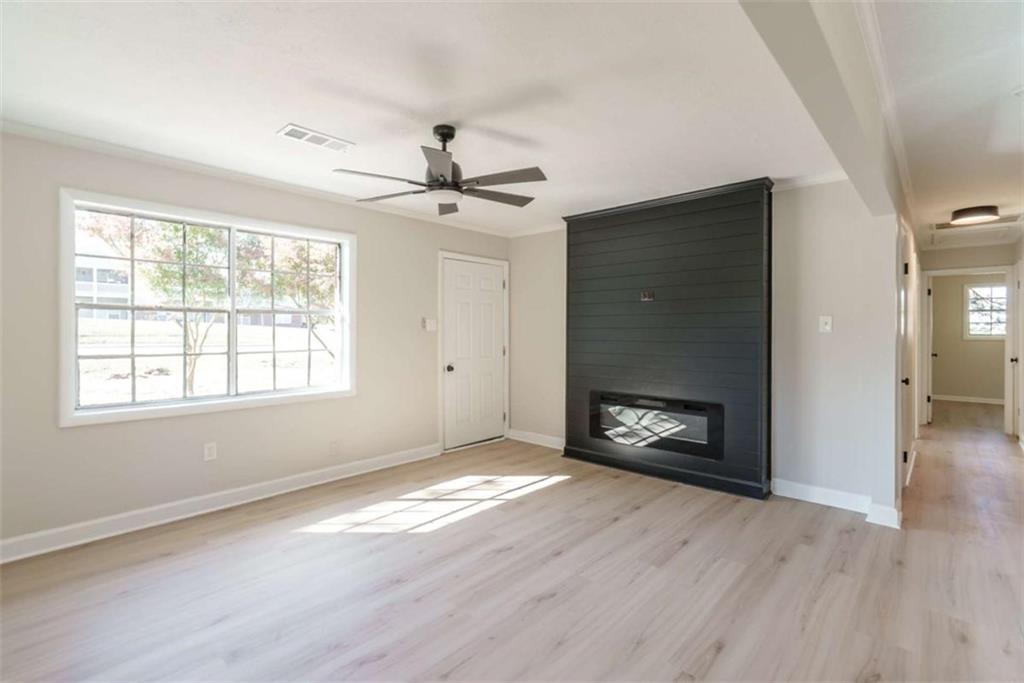 511 Lee Byrd Road Loganville, GA 30052 - Photo 8 of 32 a view of an empty room with a fireplace and a window