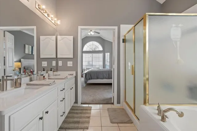 a en suite bathroom with a double vanity sink and a mirror