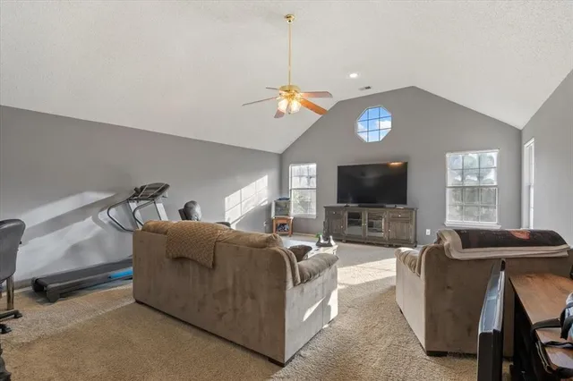 a living room with furniture a flat screen tv and a window