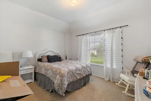 a bedroom with a bed chair and window