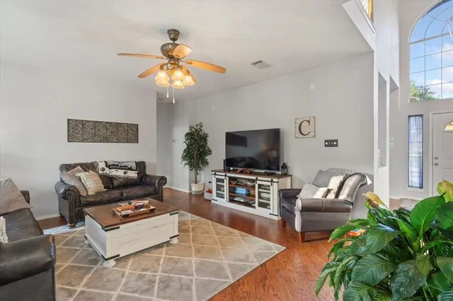 a living room with furniture a flat screen tv and a potted plant