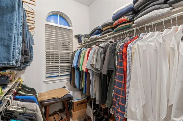 a view of walk in closet with clothes and shoes