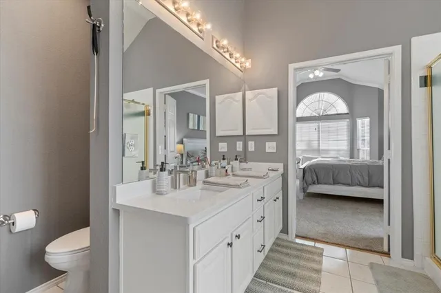 a en suite bathroom with a granite countertop sink toilet and a mirror