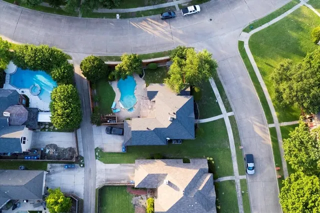 an aerial view of a house with a yard potted plants and large tree