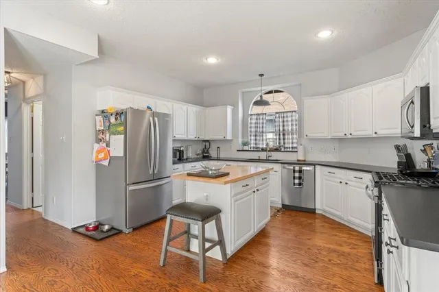 a kitchen with granite countertop a refrigerator stove top oven and sink