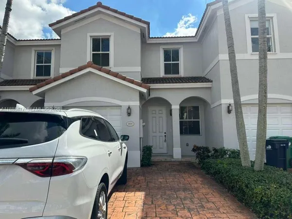 a view of a white house with large windows and a table