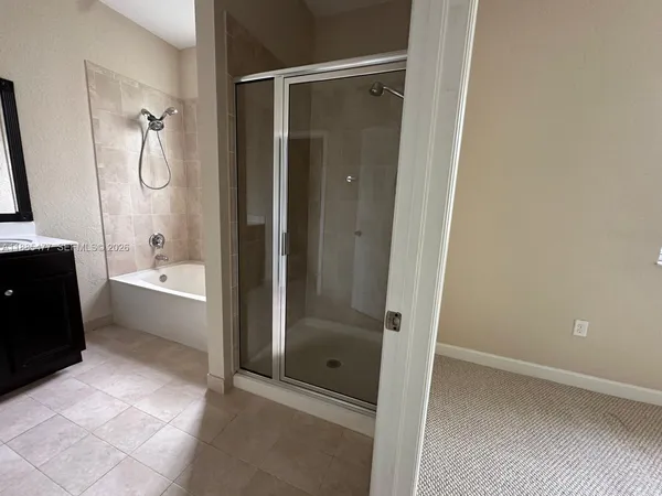 a bathroom with a glass door shower a sink and a mirror