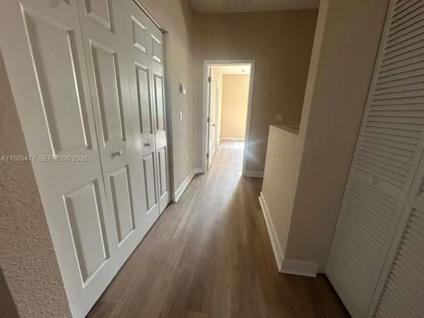 a view of a hallway and wooden floor