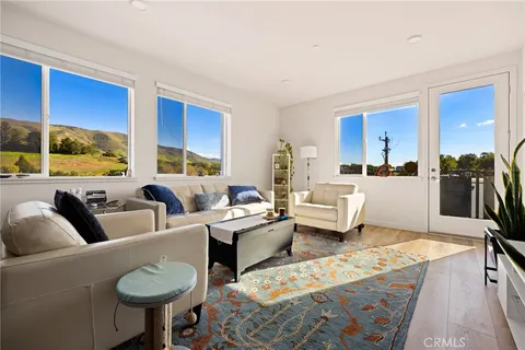 a living room with furniture a flat screen tv and a large window