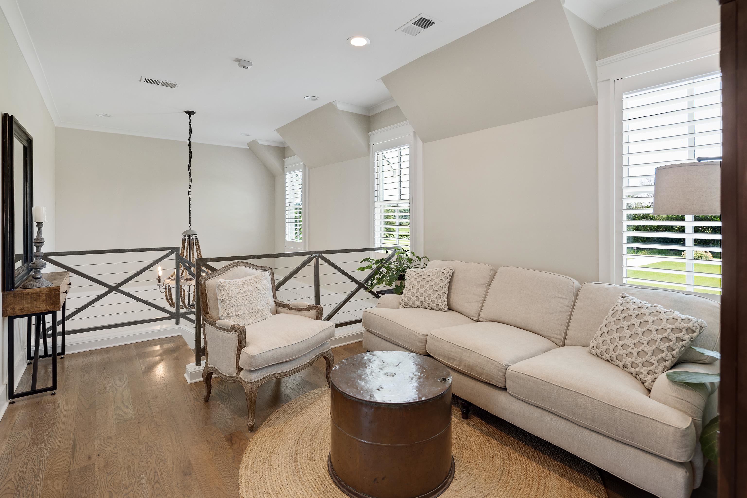 805 Shady Grove Road Williston, TN 38076 - Photo 27 of 40 Open loft area featuring wood-finish flooring, white plantation shutters, and a dark-toned railing