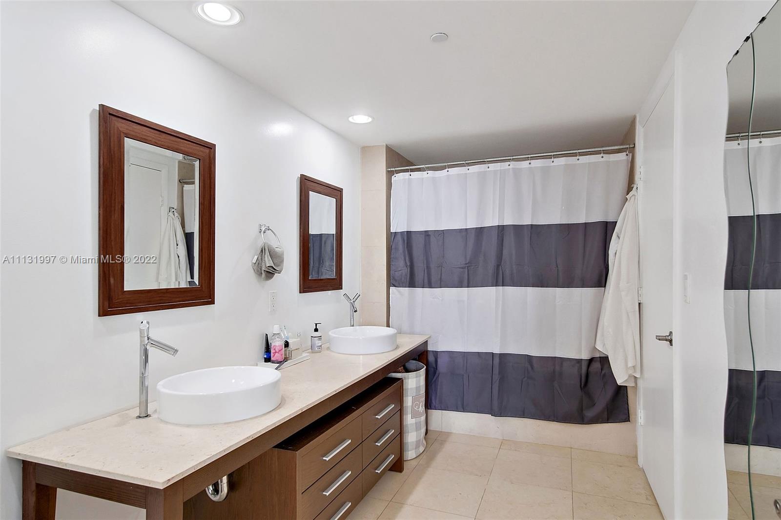 495 Brickell Avenue, Unit 3107 Miami, FL 33131 - Photo 23 of 41 a bathroom with a double vanity sink a mirror and a bathtub