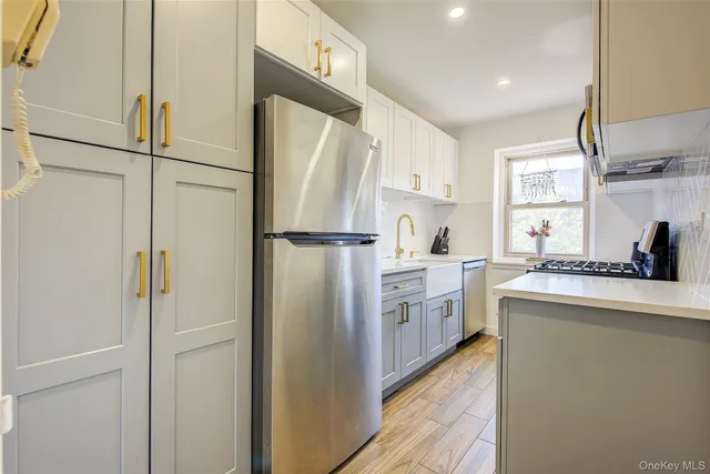 a kitchen with white cabinets and stainless steel appliances