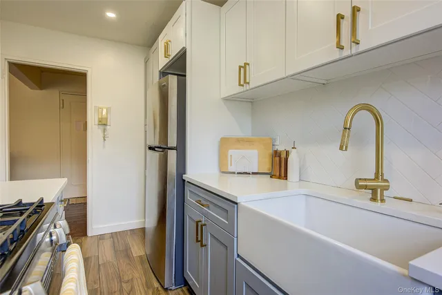 a kitchen with stainless steel appliances granite countertop a refrigerator and a stove top oven