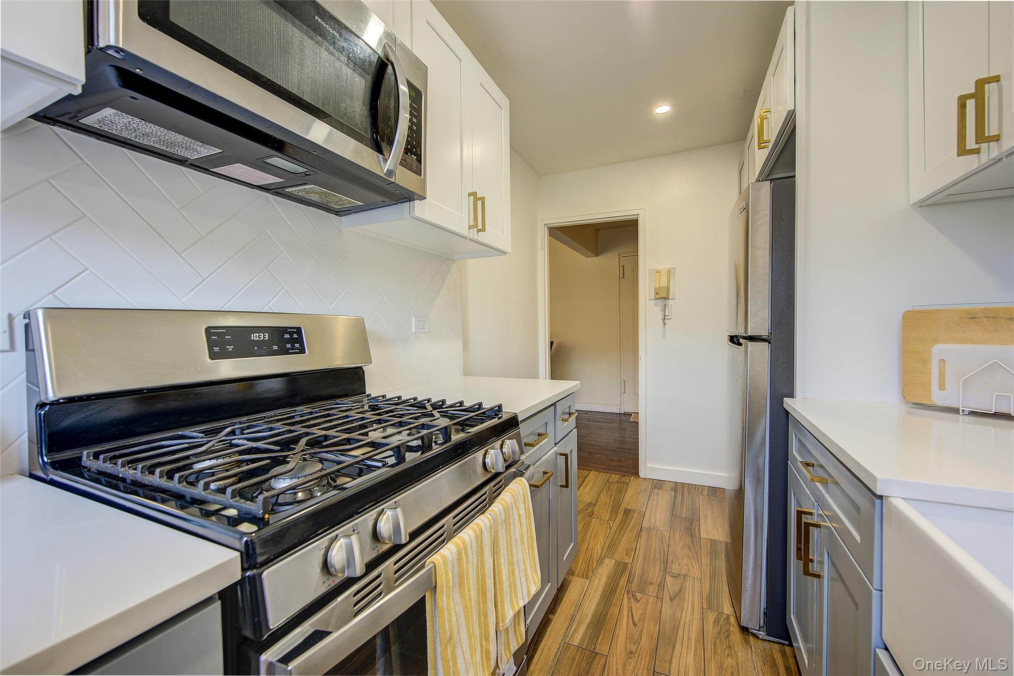 144-60 Gravett Road, Unit 4J Queens, NY 11367 - Photo 22 of 38 a kitchen with stainless steel appliances granite countertop a stove and a wooden floor