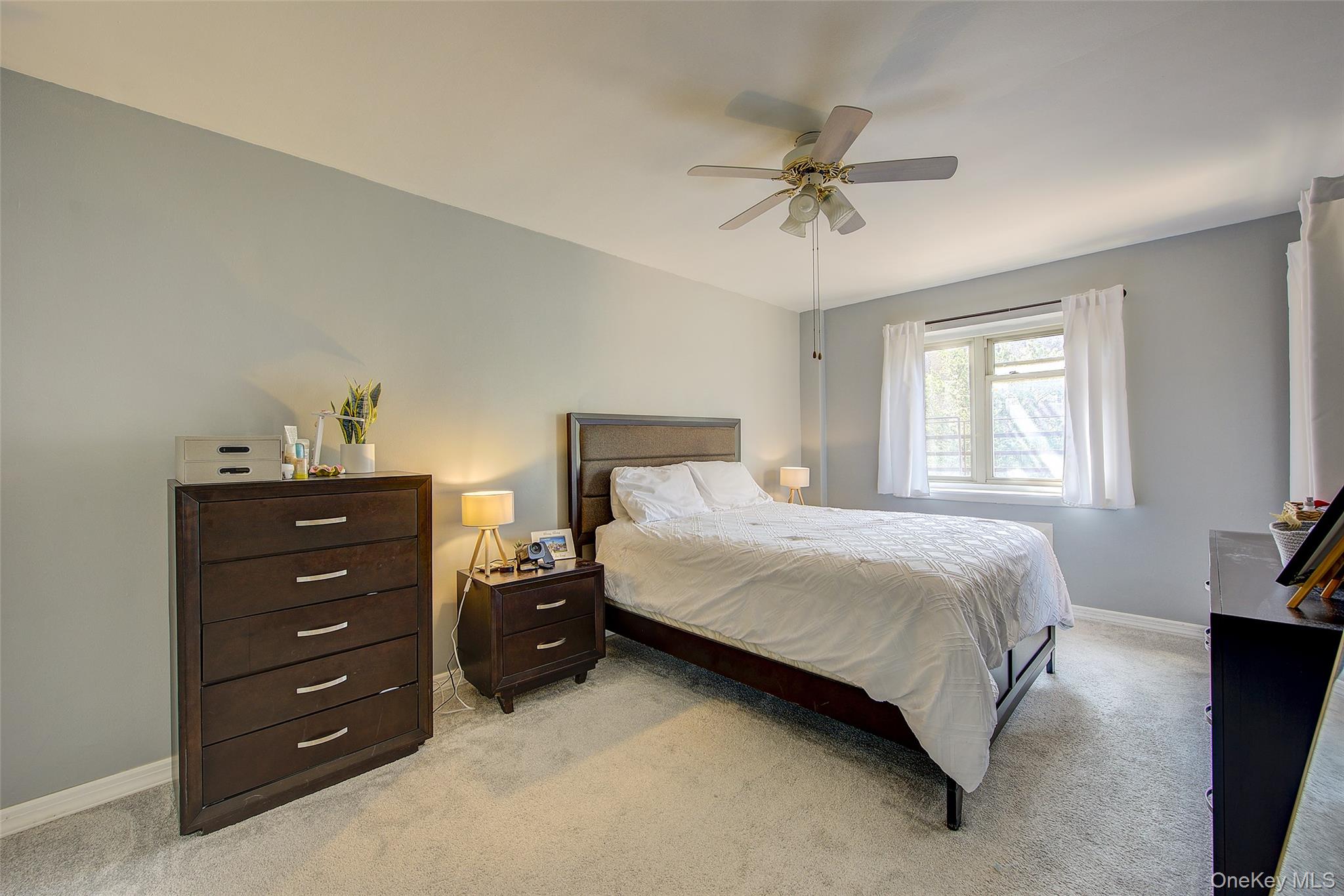 144-60 Gravett Road, Unit 4J Queens, NY 11367 - Photo 27 of 38 a bedroom with a bed and a chandelier