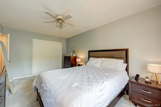 a bedroom with a bed and a ceiling fan