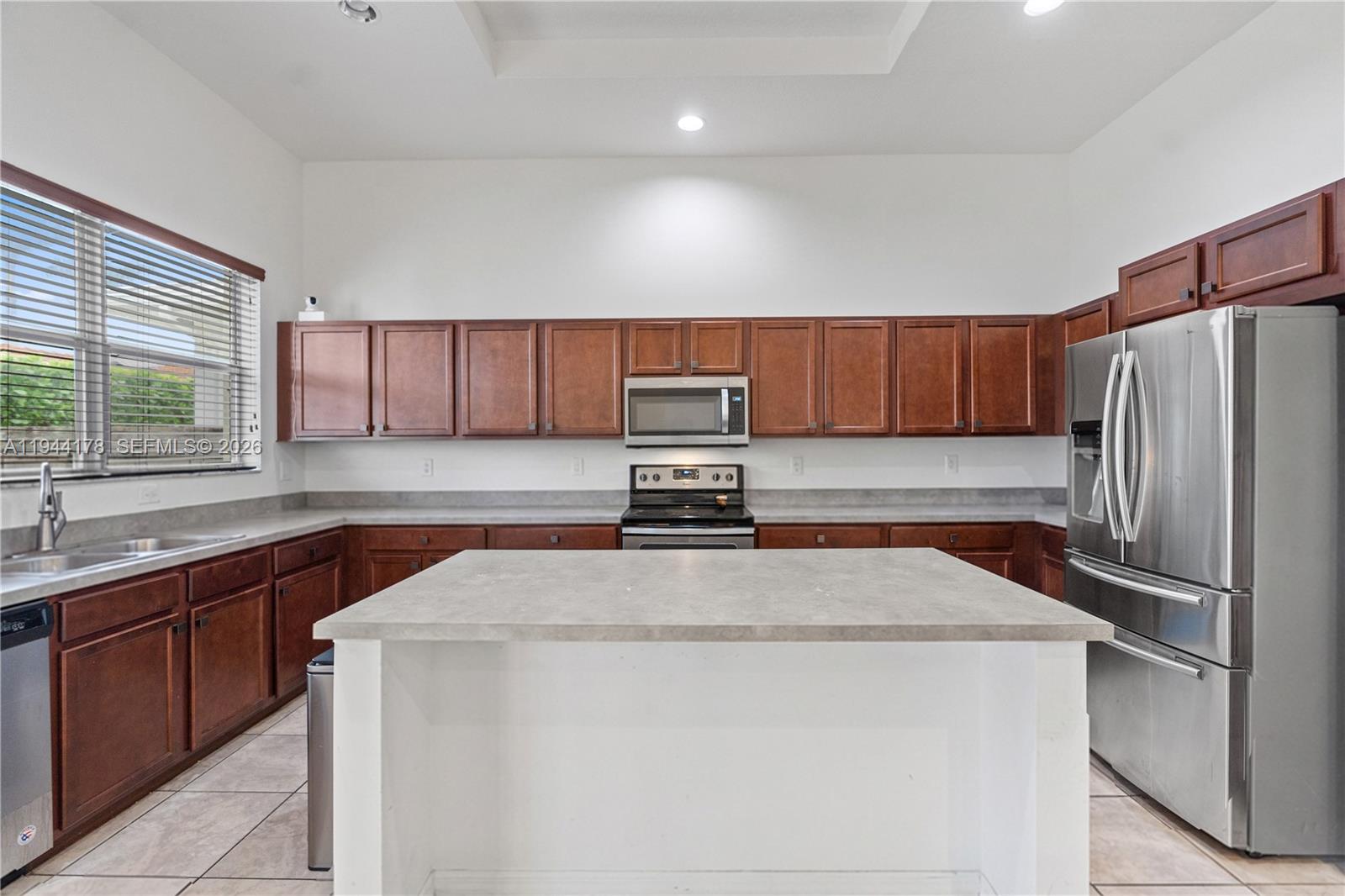 15102 Southwest 177th Terrace Miami, FL 33187 - Photo 14 of 38 a kitchen with stainless steel appliances a refrigerator sink and cabinets