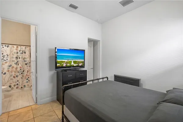 a bedroom with a bed and a flat screen tv