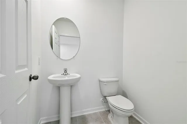 a bathroom with a toilet a sink and a mirror
