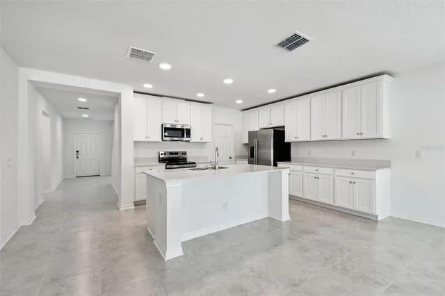 a kitchen with white cabinets and stainless steel appliances