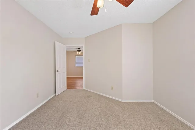 an empty room with fan and windows