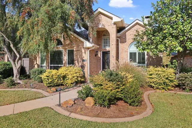 a front view of a house with a yard and potted plants