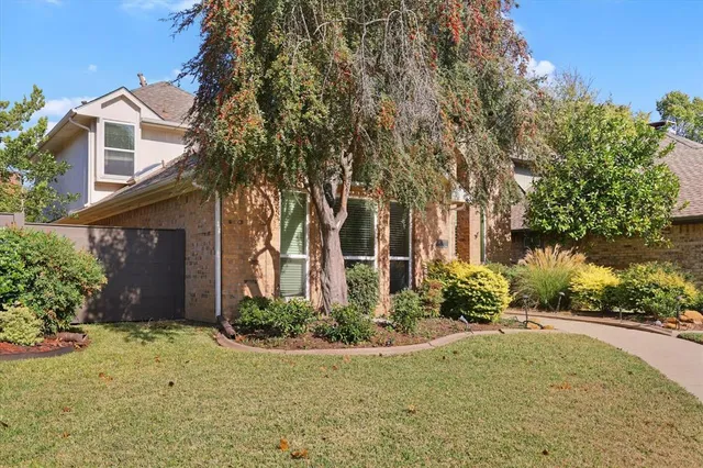 a view of a white house with a yard and potted plants