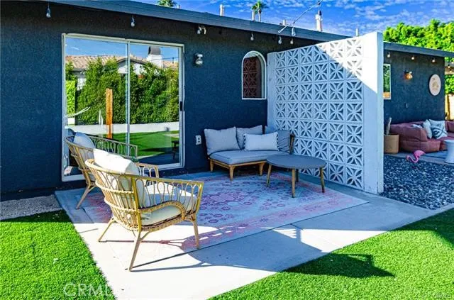 a view of a patio with couches table and chairs and potted plants