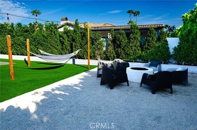 a view of a backyard with furniture and garden