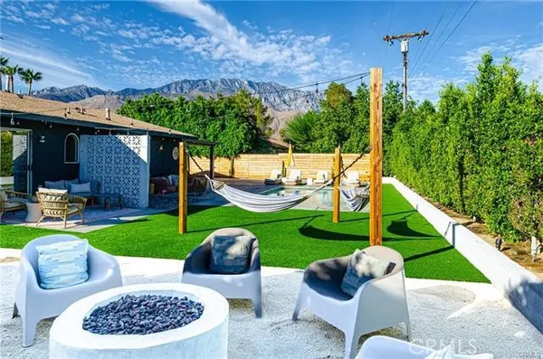 a view of a swimming pool with a chair and tables in the patio
