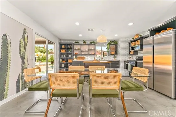 a dining room with furniture and a floor to ceiling window