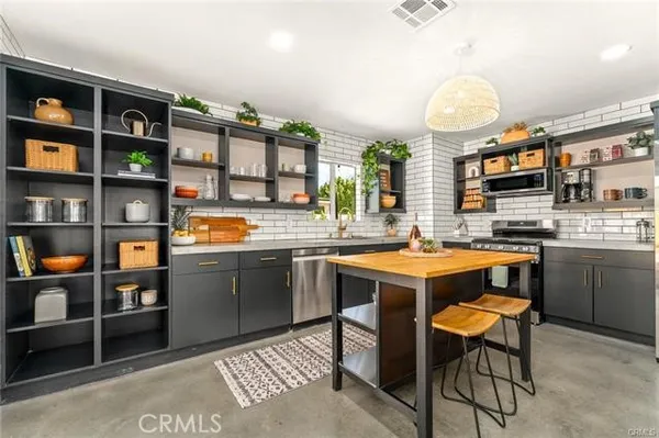 a kitchen that has a lot of cabinets a sink and a stove in it