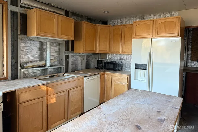 a kitchen with a sink refrigerator and cabinets