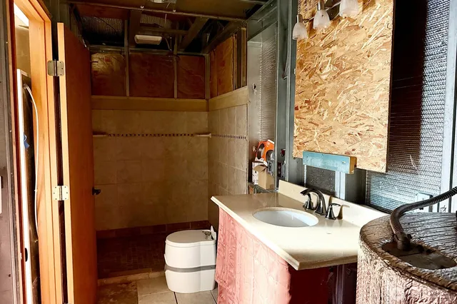 a bathroom with a granite countertop sink toilet and shower