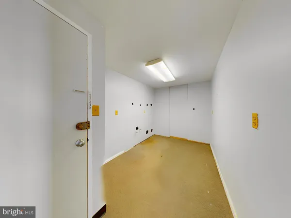 a view of empty room with a kitchen and a sink