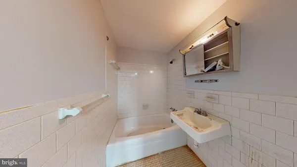 a bathroom with a bathtub a sink a toilet and shower
