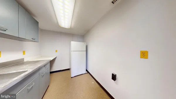 a view of an empty room and window and kitchen area