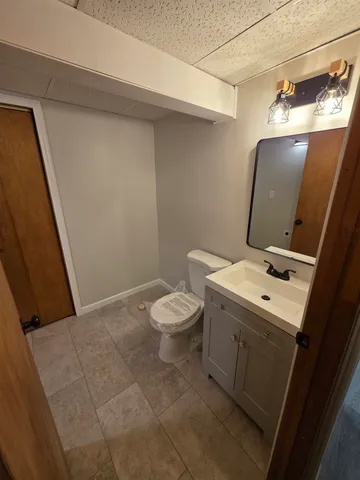 a bathroom with a toilet sink and mirror