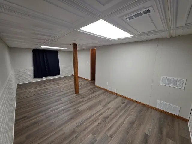 a view of an empty room with wooden floor