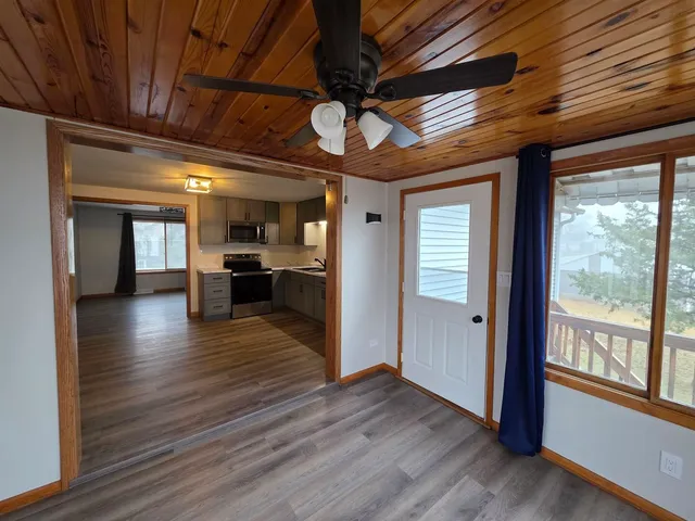 a view of empty room with wooden floor and windows