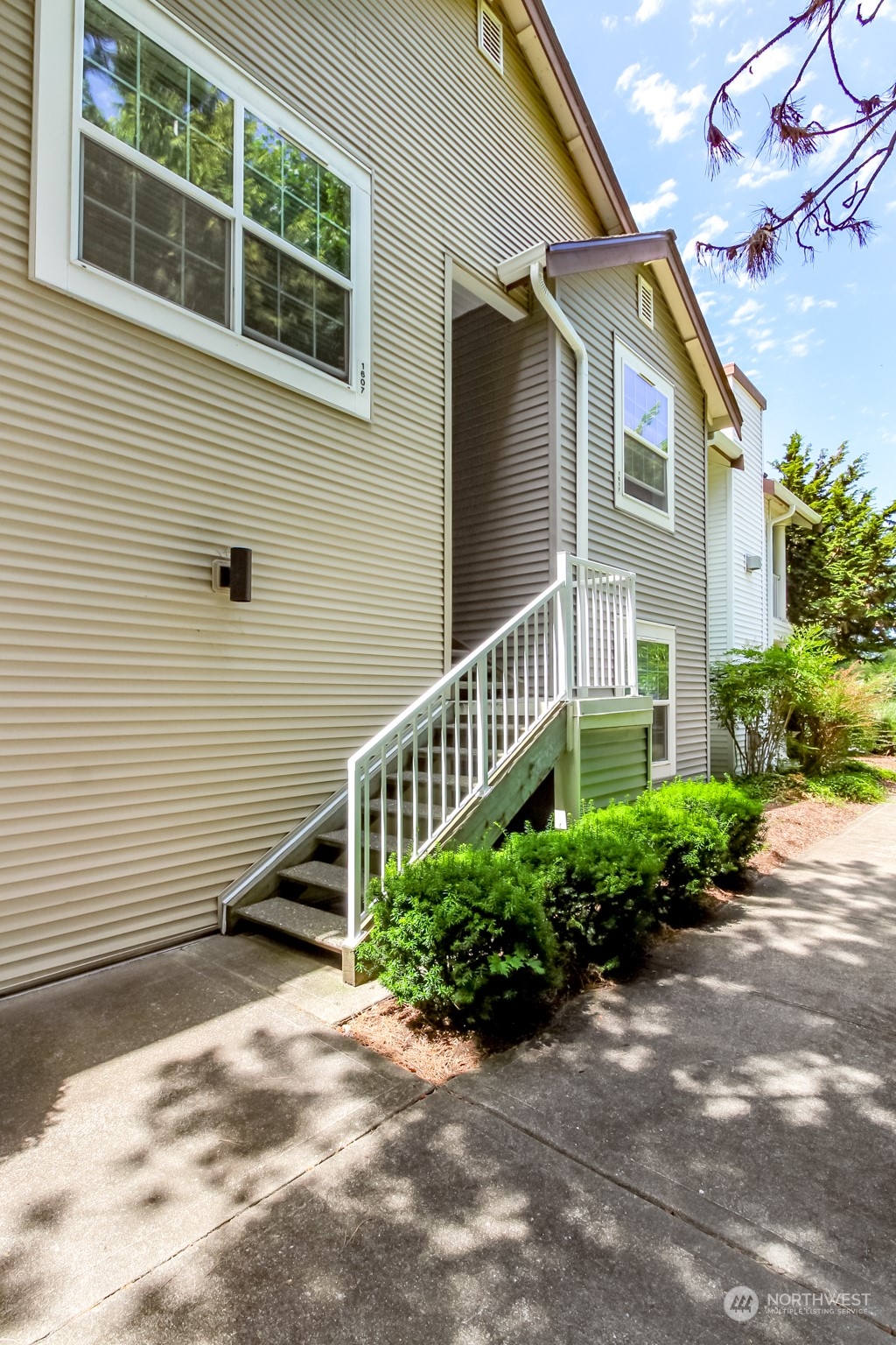 a view of a house with a yard and potted plants